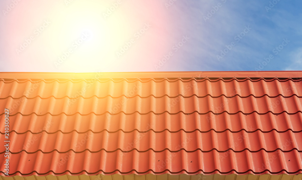 Fototapeta premium View of red roof tiles and sky with sun.