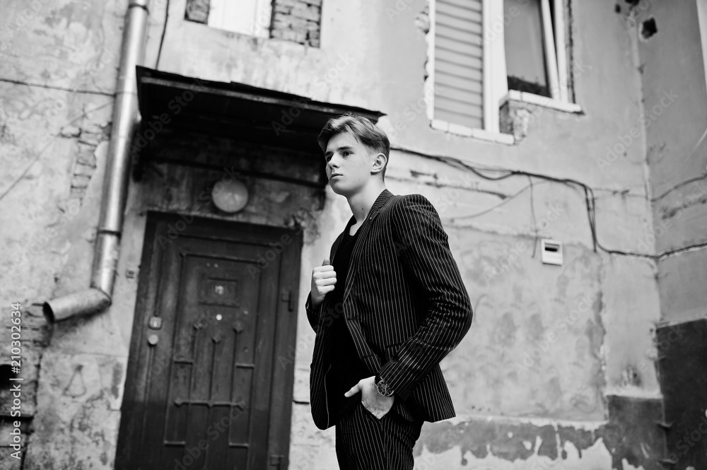 Young stylish macho boy in black jacket posed outdoor of street. Amazing model man.