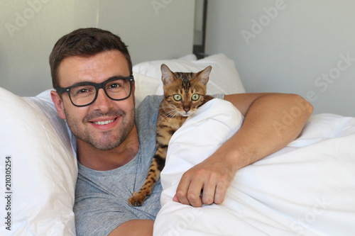 Fototapeta Naklejka Na Ścianę i Meble -  Cozy man in bed with his pet
