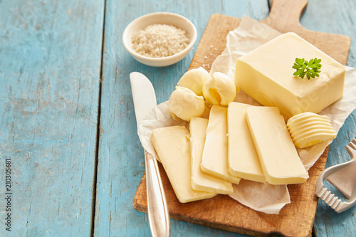 Fényképezés Block of butter sliced on wooden cutting board