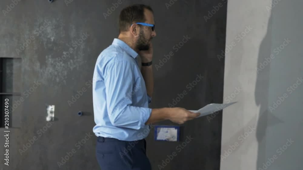 Young man with blueprints talking on cellphone at new home
Young man with blueprints talking on cellphone at new home