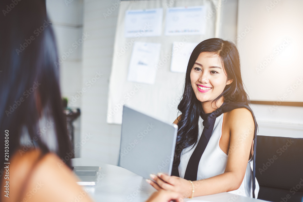 Obraz premium Young asian businesswoman in modern office, discussing with colleague and during meeting