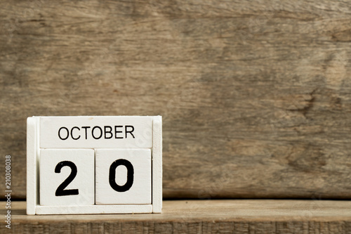 White block calendar present date 20 and month October on wood background