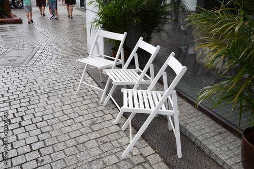 three white chairs on the street