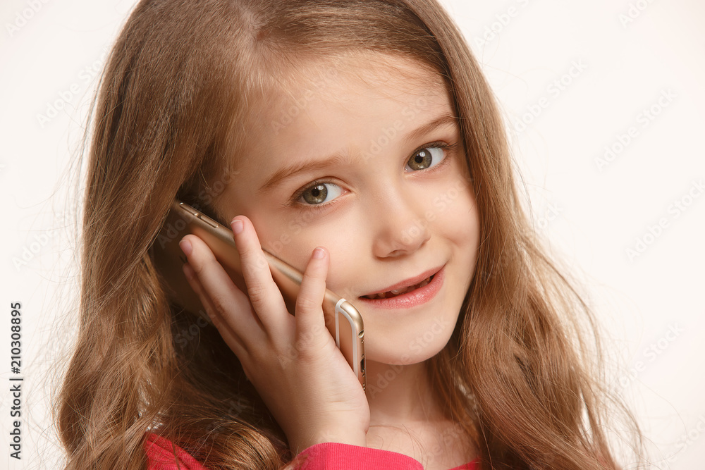 The happy teen girl standing and smiling against white background. The happy teen girl standing and smiling against white background.