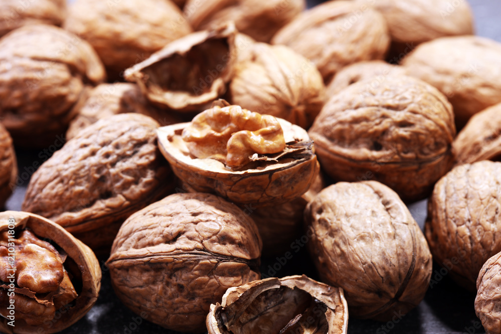 Walnut kernels and whole walnuts on rustic old table Walnut kernels and whole walnuts on rustic old table