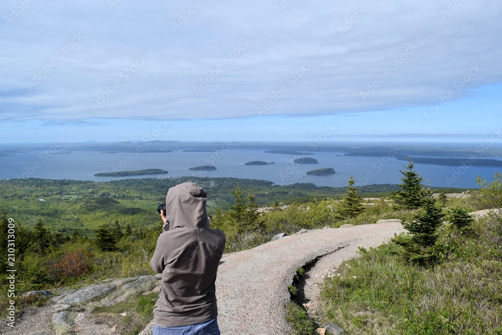 A lady taking photo on the cadilac mountain in Acadia park