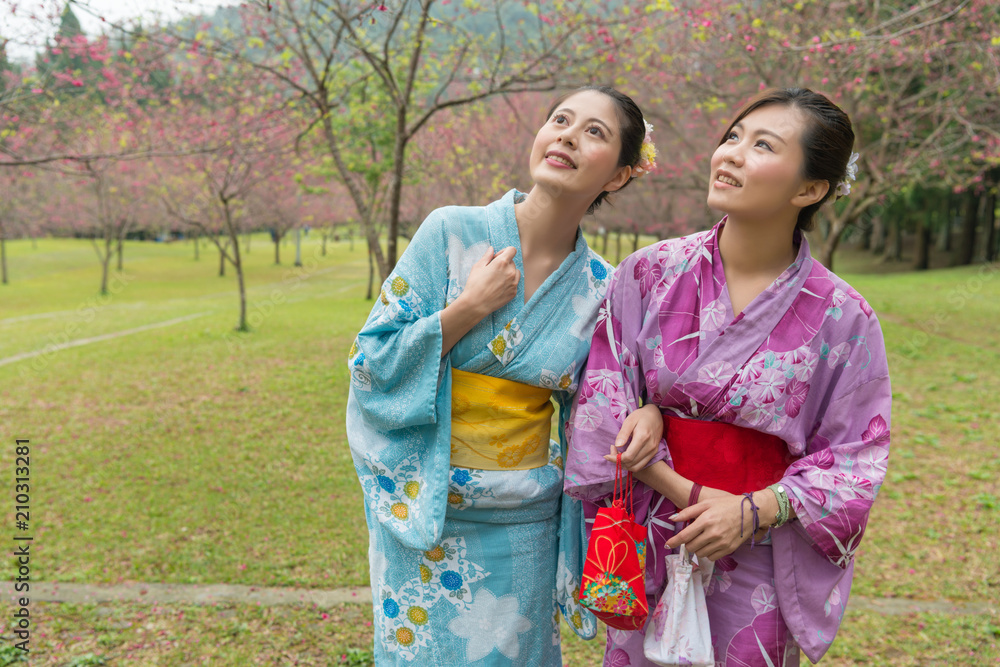 Two young Asian girls stand walking together Two young Asian girls stand walking together