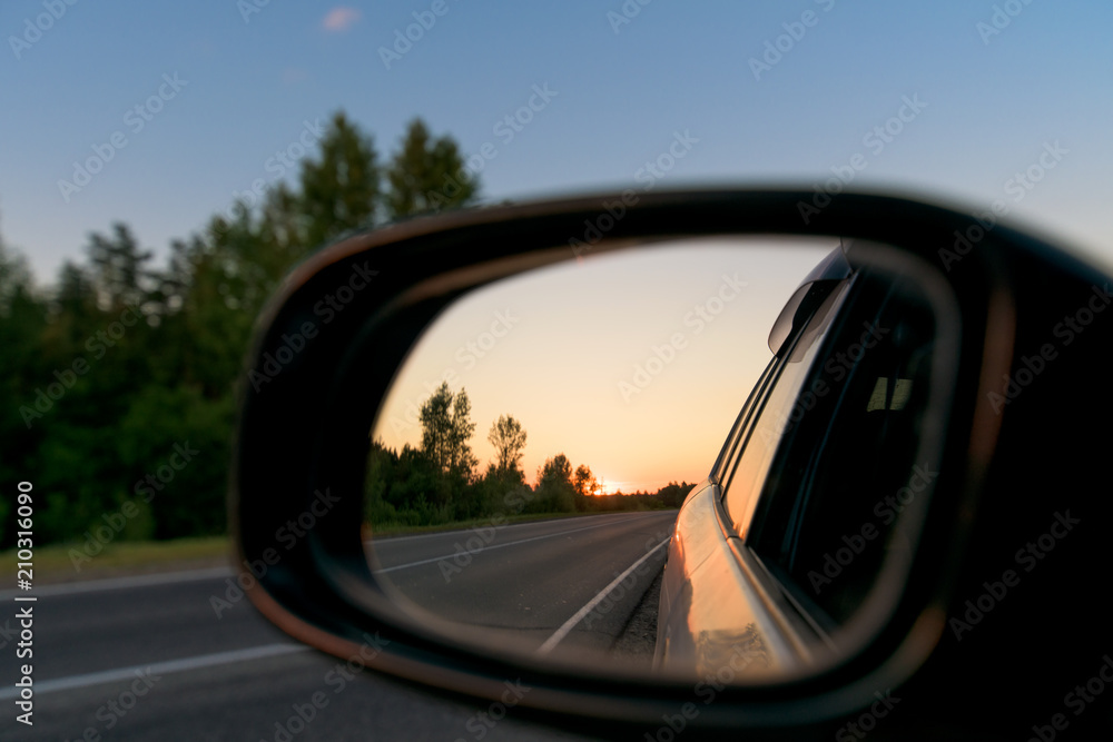 great view in the rear view mirror of the sunset. close up