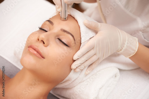 Young relaxed female having anti-wrinkle beauty procedure on face photo