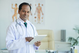 Portrait of Indian doctor using touchpad for work