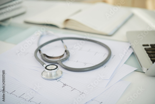 Close-up of stethoscope and cardiogram on the desk at doctor's office