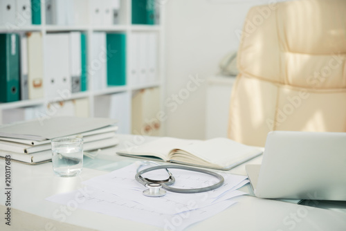 Doctor office table with stethoscope and documents photo