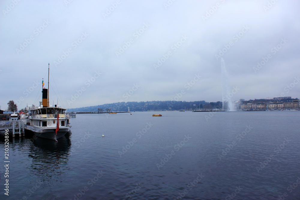 Geneva, Switzerland - March 30,2018: Swiss famous view on popular fountain,  yachts on rainy  day