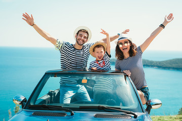 Happy family travel by car to the sea. People having fun in cabriolet. Summer vacation concept