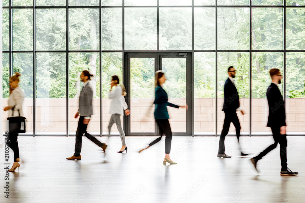 © rh2010 - Business people walking at the modern hall on the window background indoors. long exposure image technic with motion blurred people