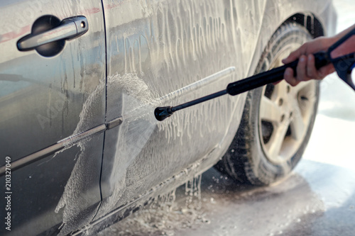Fototapeta Naklejka Na Ścianę i Meble -  Cleaning Car Using High Pressure Water. Man washing his car under high pressure water .