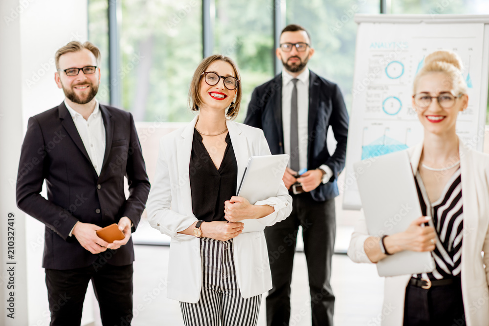 Portrait of a group of business people standing during a conference with flip chart at the modern office Portrait of a group of business people standing during a conference with flip chart at the modern office