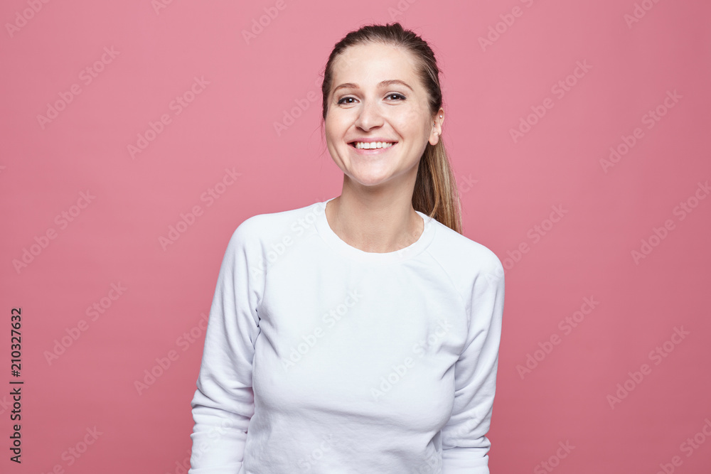 Happy woman laughing. Closeup portrait of woman with perfect smile and white teeth, looking happy, isolated over pink wall background. Positive human emotion, facial expression, body language conept. Happy woman laughing. Closeup portrait of woman with perfect smile and white teeth, looking happy, isolated over pink wall background. Positive human emotion, facial expression, body language conept.