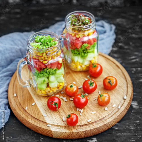 Salad with tomatoes and corn and cucumbers and lettuce. Healthy