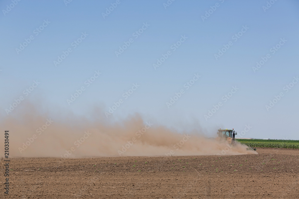 Fototapeta premium 20.06.2018 Ukraine, the Kherson region. The tractor plows the earth, on a hot summer day