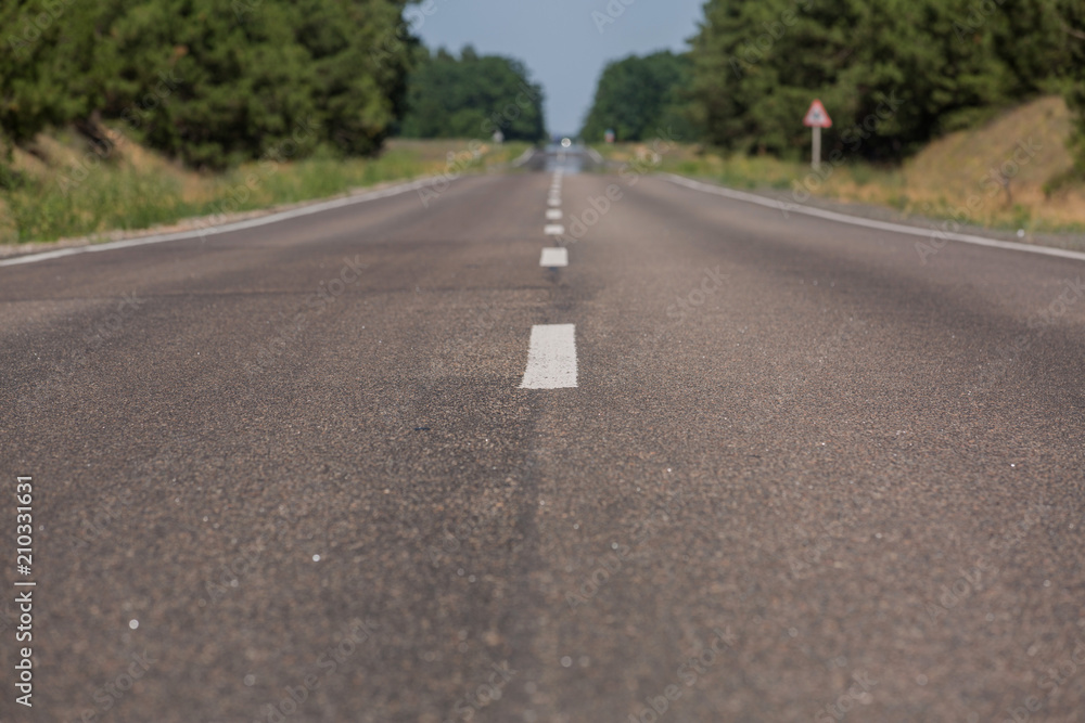 The new asphalt coating with road markings. Road in the forest The new asphalt coating with road markings. Road in the forest