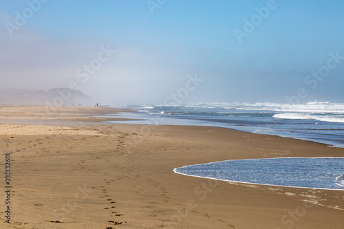 The vast sandy Ocean Beach in San Francisco, with a mist in the distance