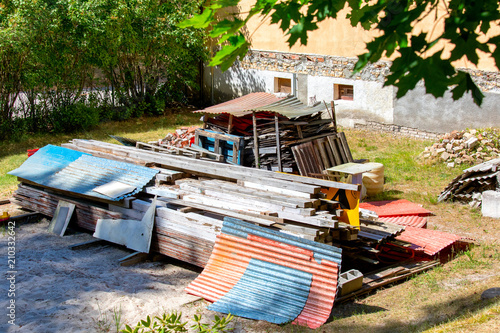 Gently stacked old building materials in courtyard of private house.Plastic and asbestos shiver,boards