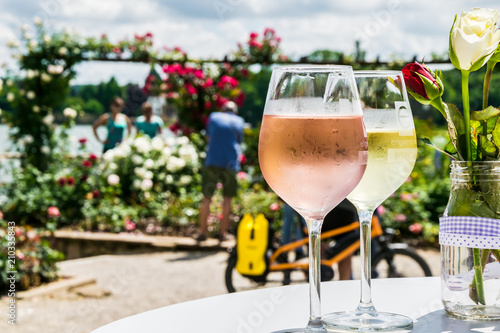 Two glasses of White Wine with Roses in the Background in Eltville in Rheinland-Pfalz in Germany photo