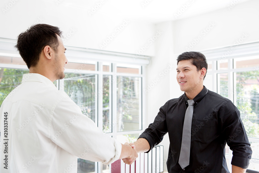 Handshake. Business associate shaking hands in office. Two businessmen shaking hands in office. Handshake. Business associate shaking hands in office. Two businessmen shaking hands in office.