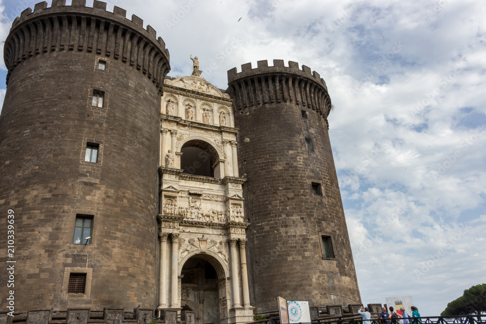 Naples, Italy - 13/06/2018: Castel-Nuovo fortress against blue sky. Italian medieval architecture. Italy travel. Fortification and protection concept. Eorupean vacations. Napoli landmark.
