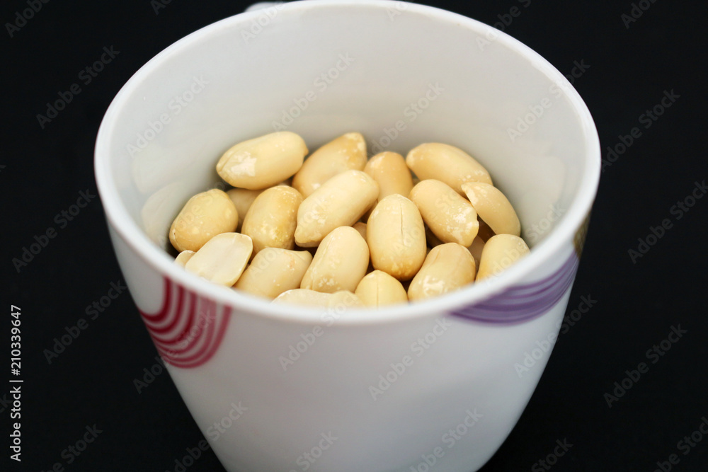 Detail of delicious peanuts in white cup Detail of delicious peanuts in white cup