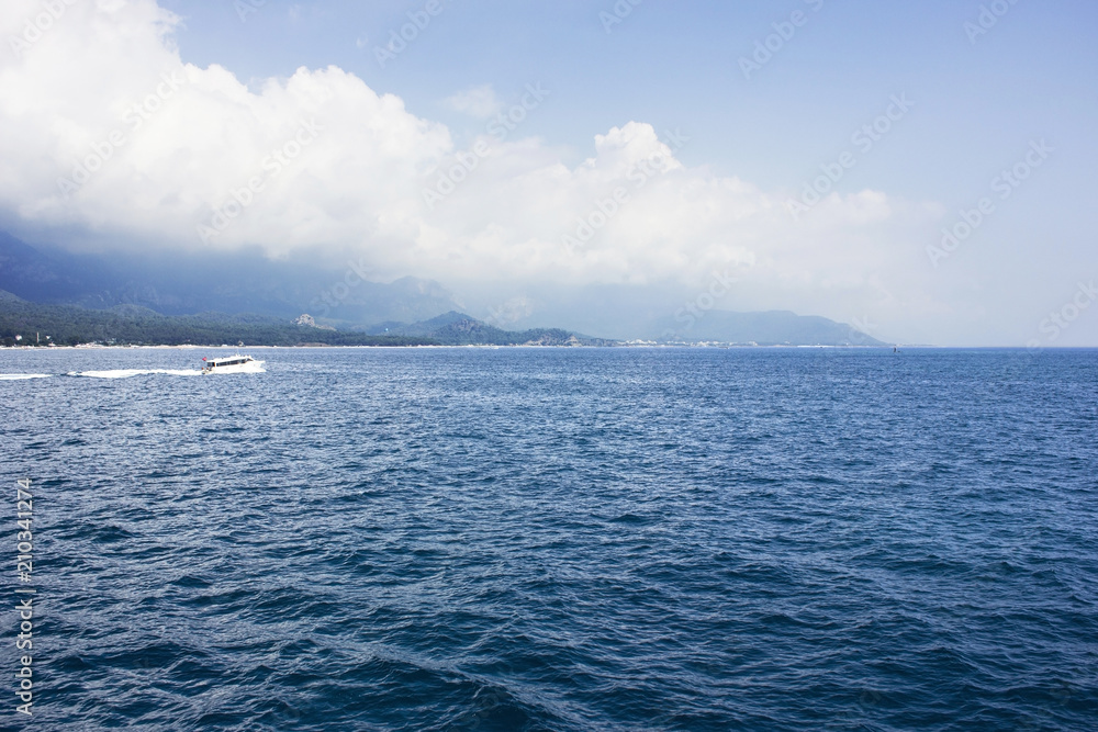 Blue calm Mediterranean Sea, mountains and white yacht