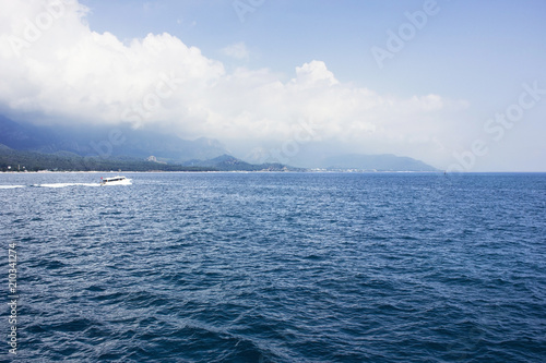 Blue calm Mediterranean Sea, mountains and white yacht