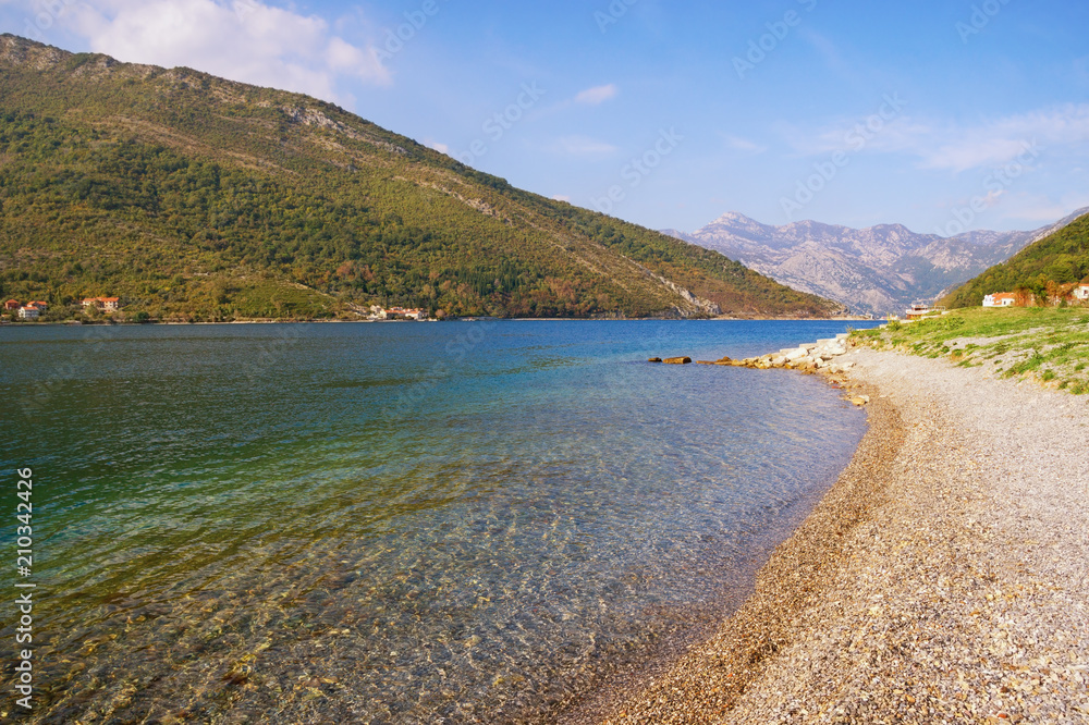 Beautiful autumn Mediterranean landscape  - mountains, sea, deserted beach and blue sky. Montenegro, view of Bay of Kotor (Adriatic Sea) near Verige Strait