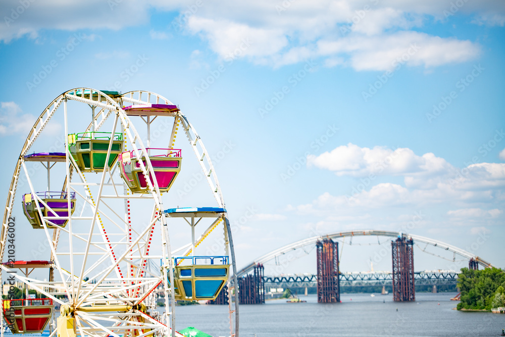 Ferris wheel on cloudy sky background