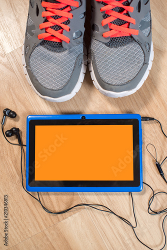 A tablet with some clothes and acessories flatlay on wooden background