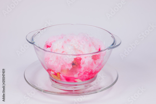 A glass of sweet ice with milk and red syrup with white background