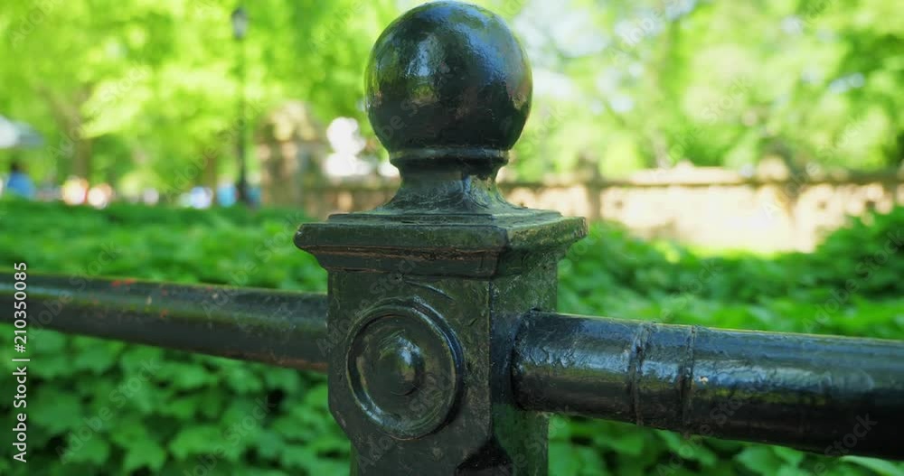 A slow dolly establishing shot of a railing on The Mall in New York City's iconic Central Park. Shallow depth of field with unidentifiable tourists in the background. A slow dolly establishing shot of a railing on The Mall in New York City's iconic Central Park. Shallow depth of field with unidentifiable tourists in the background.