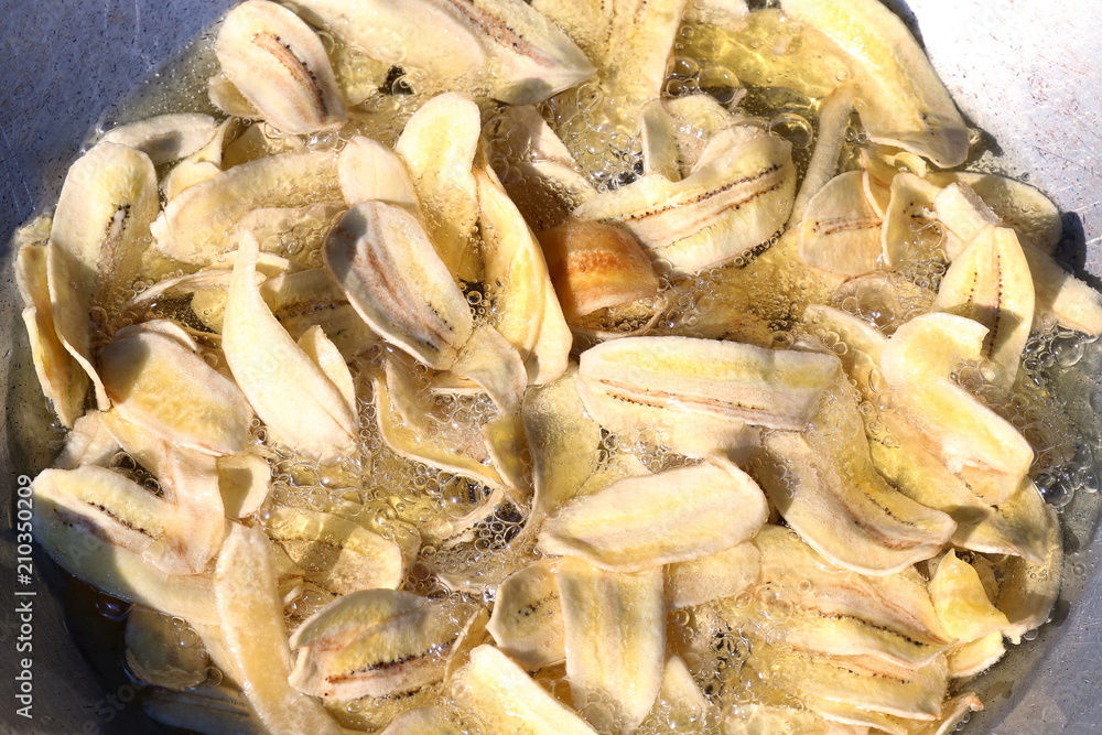 Banana fried pieces slice thin in boiling oil, Banana fried snack Banana fried pieces slice thin in boiling oil, Banana fried snack
