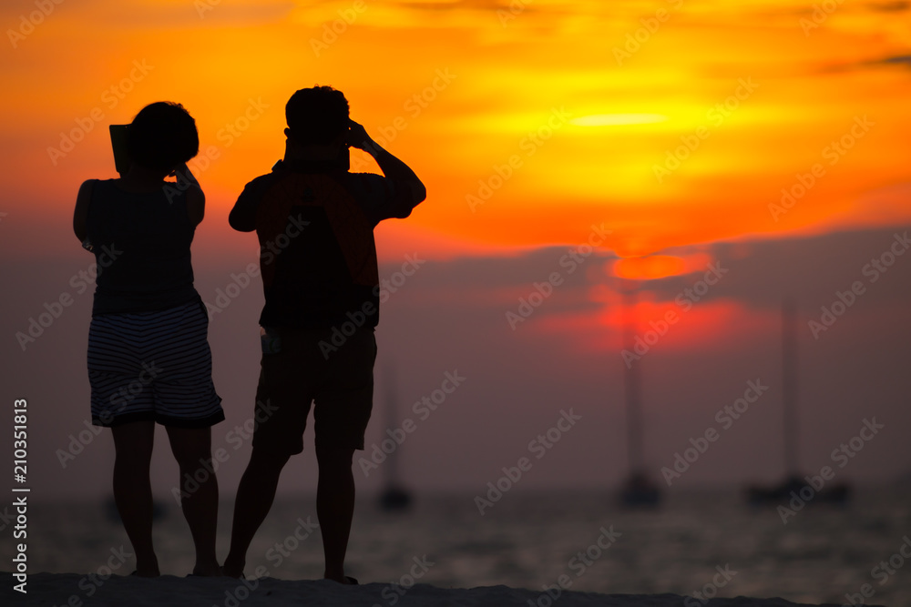 Happy romantic couple taking photo sunset on beach