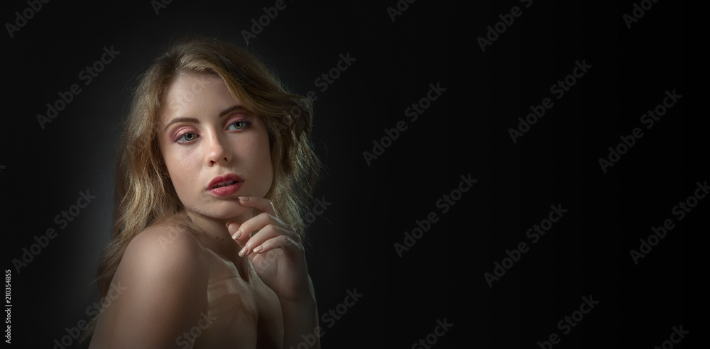 Naklejka premium Beautiful sexy blonde on a black background .