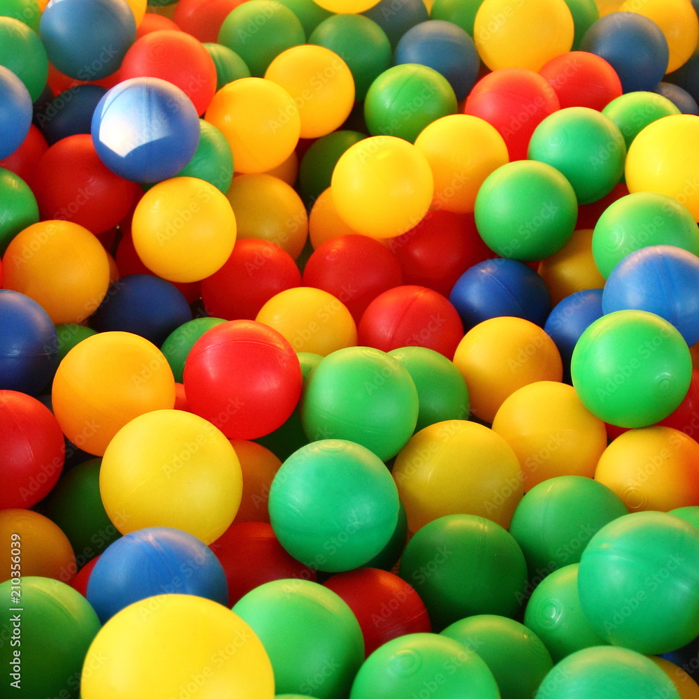 Children's party, toys – a lot of colorful plastic balls in a dry pool: red, green, blue, yellow. Children's party, toys – a lot of colorful plastic balls in a dry pool: red, green, blue, yellow.