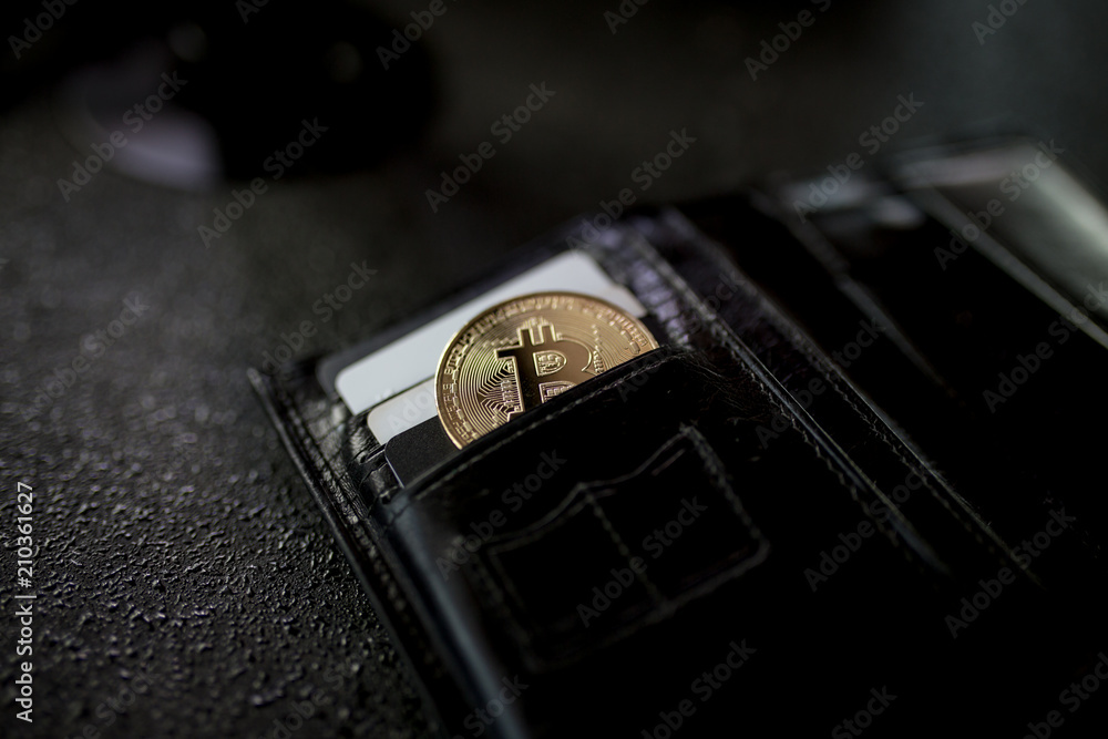 Metal bitcoin in black leather wallet. Metal bitcoin in black leather wallet.