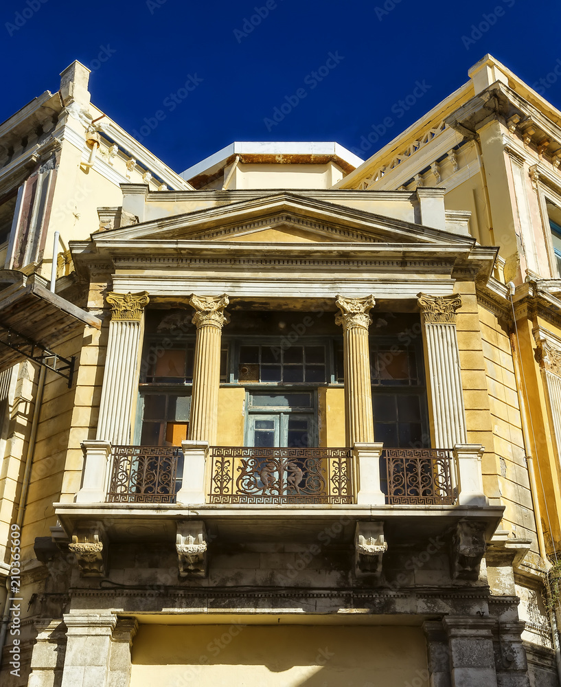 Facade house built in classical Roman style with columns and balcony Facade house built in classical Roman style with columns and balcony