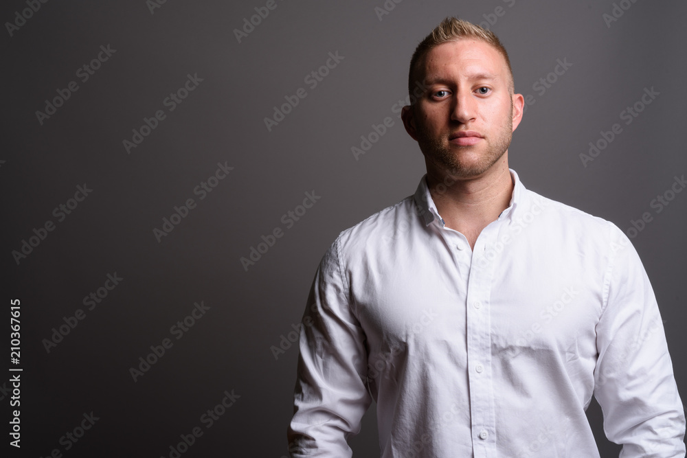 Businessman with blond hair against gray background Businessman with blond hair against gray background