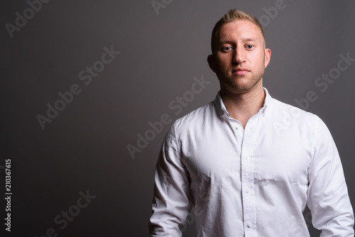 Businessman with blond hair against gray background