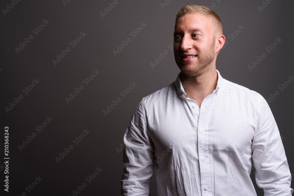 Businessman with blond hair against gray background Businessman with blond hair against gray background