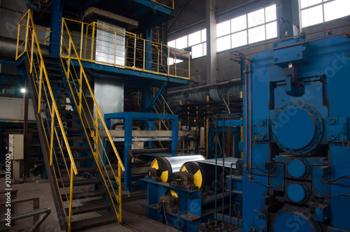 Manufacture of galvanized steel by rolling. Galvanized steel passes through coils. Roll of galvanized steel or metal on machine in industrial workshop on rolling mill, manufacturing metalwork factory