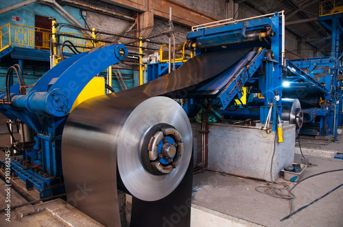 Manufacture of galvanized steel by rolling. Galvanized steel passes through coils. Roll of galvanized steel or metal on machine in industrial workshop on rolling mill, manufacturing metalwork factory 